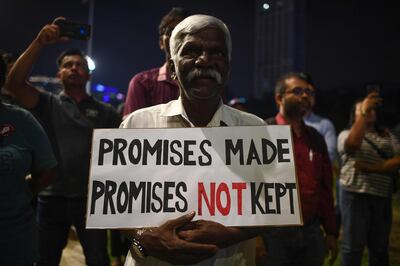 A man holds a sign at a protest against a national government being formed without new elections at Independence Square in Kuala Lumpur on February 25, 2020. Intense political jockeying is underway to form a new government in Malaysia after Mahathir Mohamad, the world's oldest leader, resigned then was appointed interim leader. / AFP / Mohd RASFAN
