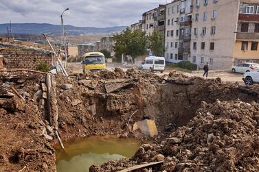 A man walks past a crater formed by an aerial bomb in Stepanakert, Nagorno-Karabakh on October 11, 2020. On the day after a ceasefire was broken between Azerbaijan and Armenia, war continues to wage between the two countries over the contested Nagorno-Karabakh region. Getty Images