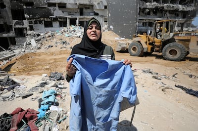 A woman holds a discarded item of clothing as rescuers and medics search for bodies in the ruins of Al Shifa Hospital. Reuters