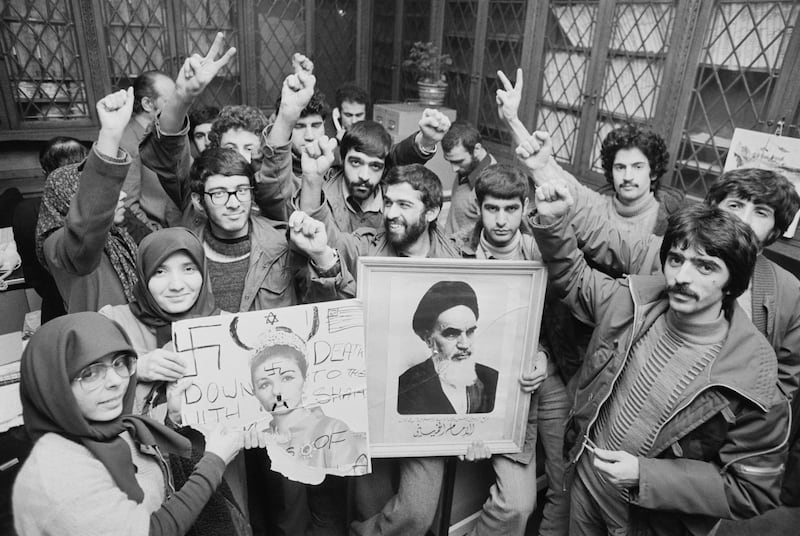 A group of anti-monarchy students hold pictures of the Shah and his wife as they celebrate the end of his rule, in the UK in January 1979. Getty Images