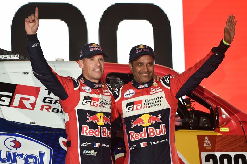 Toyota Gazoo Racing's Qatari driver Nasser al-Attiyah (R) and his French co-driver Matthieu Baumel wave during the podium ceremony in Jeddah ahead of the 2020 Dakar Rally. AFP