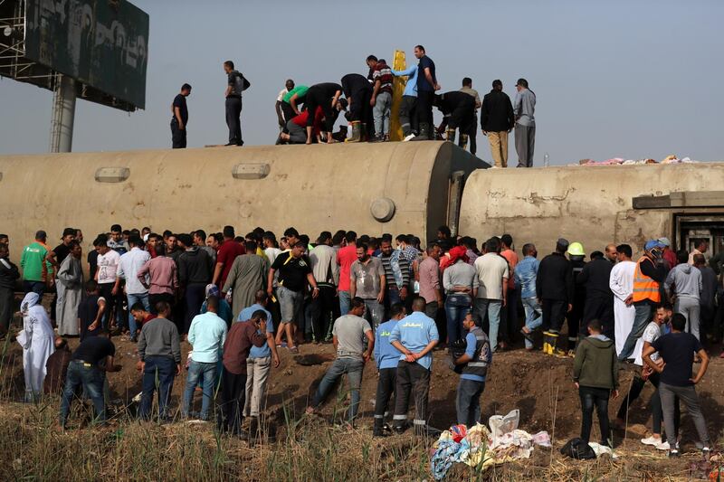 People inspect the damage at the site where train carriages derailed in Qalioubia province, north of Cairo, Egypt. Reuters