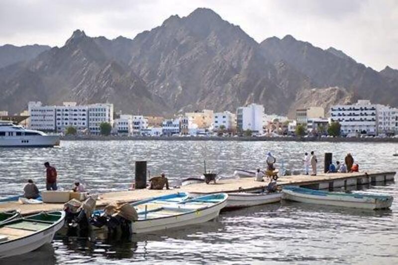 Fishermen and delivery staff work near the Mina Sultan Qaboos in downtown Muscat, against the backdrop of the Muttrah district corniche, on May 21, 2013. Silvia Razgova / The National