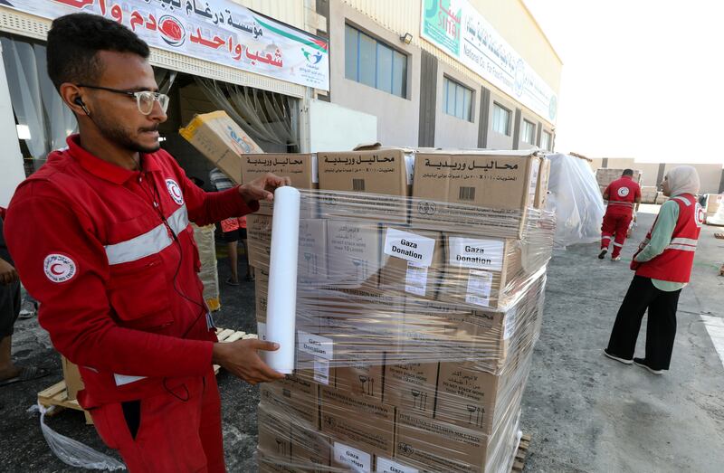 Red Crescent Society employees and volunteers handle humanitarian aid bound for Gaza at a warehouse in Arish, Egypt. EPA