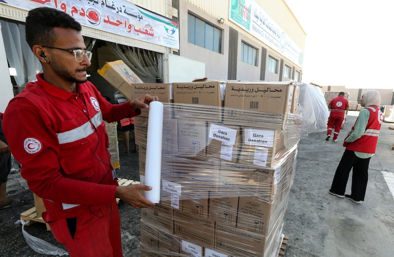 Red Crescent Society employees and volunteers handle humanitarian aid bound for Gaza at a warehouse in Arish, Egypt. EPA