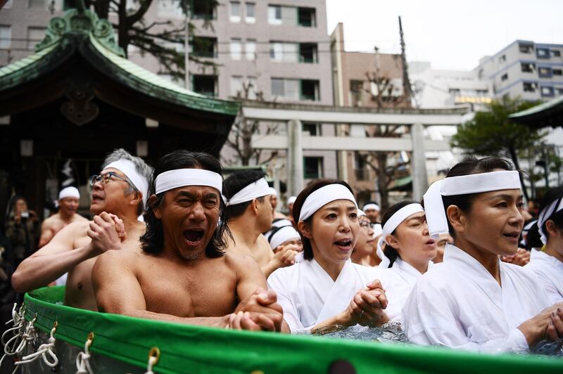Shinto believers of the Teppozu Inari Shrine take a bath in cold water to purify their souls and bodies.  AFP