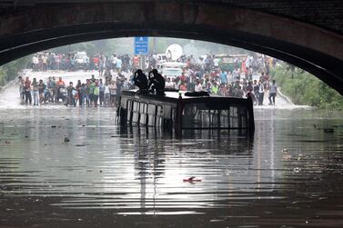 Passengers stand on top of a half-submerged Delhi bus after heavy rain in New Delhi, July 2018. EPA / Harish Tyagi