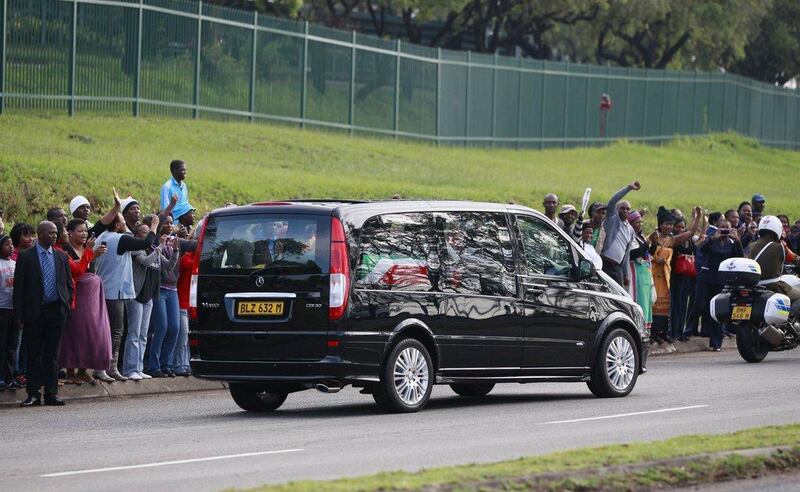 People cheer as the funeral cortege carrying the coffin of former South African President Nelson Mandela leaves the 1 Military Hospital on the outskirts of Pretoria today, on its way to the Union Buildings. Thomas Mukoya / Reuters