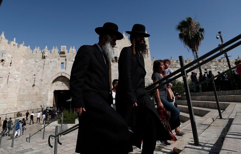 epa09260484 Ultra-Orthodox men walk by at Damascus gate during the visit of Israeli far-right member of (Otzma Yehudit) party and the Knesset (parliament) Itamar Ben-Gvir, to  Damascus gate of Jerusalem’s old city, on 10 June 2021.  EPA/ATEF SAFADI