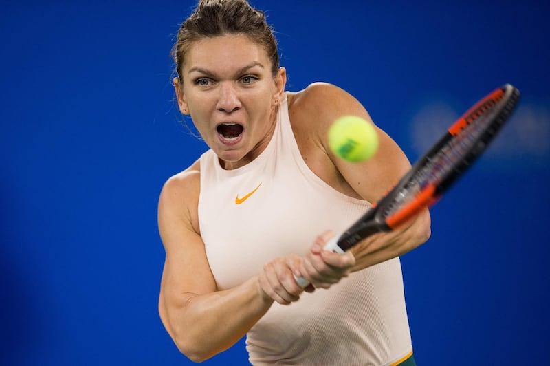 (FILES) In this file photo taken on September 26, 2018 Simona Halep of Romania hits a return against Dominika Cibulkova of Slovakia during their women's singles third round match of the WTA Wuhan Open tennis tournament in Wuhan on September 25, 2018. World number one Simona Halep on October 18 withdrew from the WTA Finals in Singapore due to a back injury, the latest tournament she has been forced to abandon. / AFP / Nicolas ASFOURI
