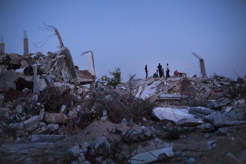 Gazans on top of piles of rubble in a neighbourhood that saw 60% of the buildings destroyed.