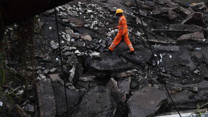 A worker walks through rubble at the collapse site. AFP
