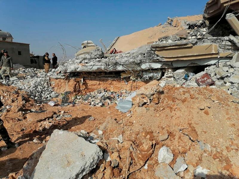 Fighters from the Kataib Hezbollah  inspect the destruction of their headquarters. AP Photo