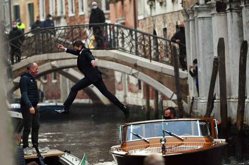 US actor Tom Cruise (C) jumps between two taxiboats during the shooting of the film  "Mission Impossible: Lybra" in Venice.   AFP