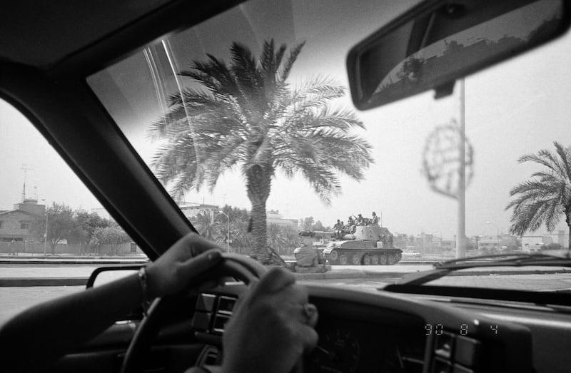 FILE - In this Aug. 4, 1990 file photo, Iraqi soldiers ride on top of one of their tanks through the streets of Kuwait City, two days after the Iraqi invasion of Kuwait. The photo was taken through the window of a passing car. The oil-rich, tiny country of Kuwait is still shaped by the 1991 Gulf War. Twenty-five years later, there is a freely elected parliament in place but problems persist and many fear Kuwait could be gripped by the same regional tensions at play across the greater Middle East. (AP Photo/Stephanie McGehee, File)