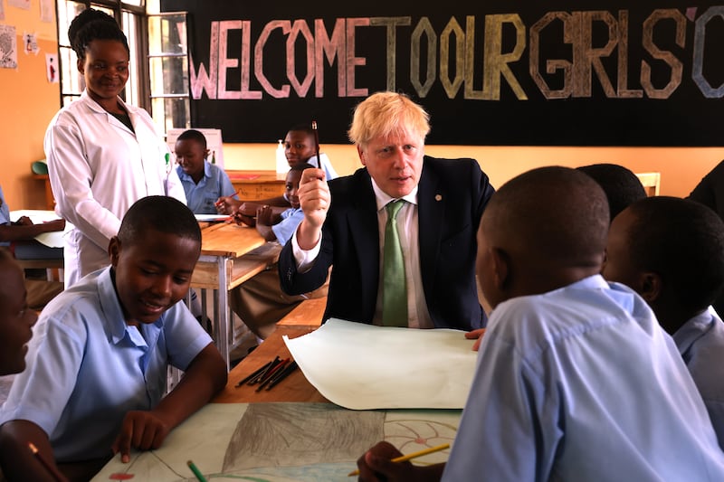 Boris Johnson interacts with pupils during a visit to the GS Kacyiru II school on the sidelines of the Commonwealth Heads of Government Meeting in Kigali. Getty Images