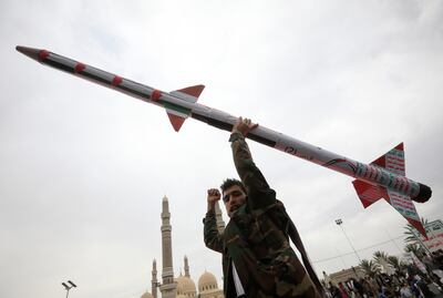 A Houthi supporter holds a mock missile during a protest against the US and Israel. EPA