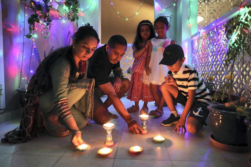 DUBAI, UNITED ARAB EMIRATES , November 14 – 2020 :- Baljeet Singh with his wife Rajwinder Kaur and kids light the lamps for Diwali festival at his home in Dubai. Diwali is the Indian festival of lights. People do prayers and exchange gifts and sweets on this day. (Pawan Singh / The National) For News/Standalone/Online/Instagram/Big Picture