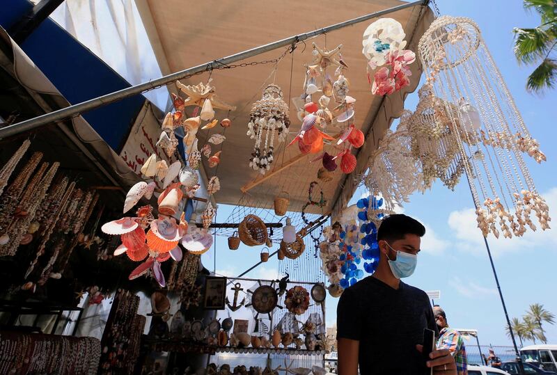 A man wearing a face mask stands in a tourist shop near the closed sea castle of the port city of Sidon, Lebanon. Reuters