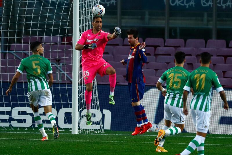 Betis' goalkeeper Claudio Bravo, second left, clears the ball past Barcelona's Lionel Messi. AP