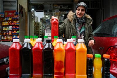 A woman selling juice on a street waits for customers during Ramadan in Beirut. EPA 