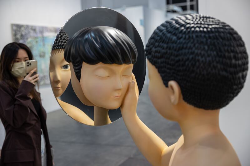 A visitor takes photos of a sculpture by Gongkan entitled 'A Boy and Someone from Nowhere' at Art Basel in Hong Kong, China.  The 2022 edition of Art Basel features 130 exhibitors. EPA