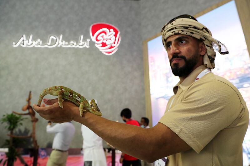 Staff from Al Ain Zoo show visitors reptiles at the Abu Dhabi stand.