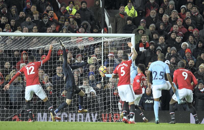 Manchester City's Spanish midfielder David Silva scores the opening goal past Manchester United's Spanish goalkeeper David de Gea (2L) during the English Premier League football match between Manchester United and Manchester City at Old Trafford in Manchester, north west England, on December 10, 2017. (Photo by Oli SCARFF / AFP) / RESTRICTED TO EDITORIAL USE. No use with unauthorized audio, video, data, fixture lists, club/league logos or 'live' services. Online in-match use limited to 75 images, no video emulation. No use in betting, games or single club/league/player publications. / 