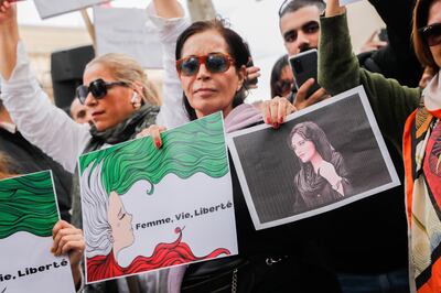 Women hold a picture of Mahsa Amini near the Iranian embassy in Paris. EPA