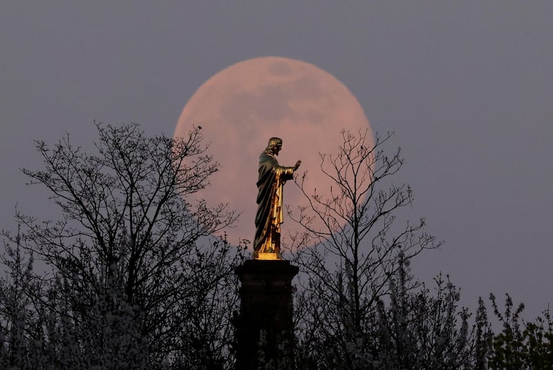 The pink supermoon rises behind the Sacre-Coeur du Horn statue of Christ, in Wolxheim, near Strasbourg, France. Reuters