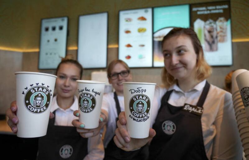 Workers of the Stars Coffee show coffee cups with logo of Stars Coffee after former Starbucks coffee shops are reopened as Stars Coffee in Moscow, Russia. Anadolu Agency via Getty Images