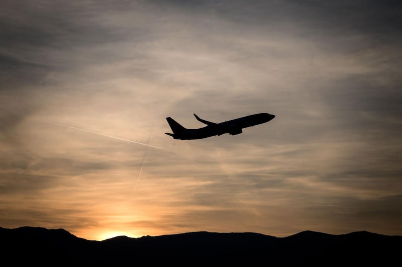 A commercial plane takes off after sunset from Geneva Airport in Geneva on July 18, 2019.  / AFP / FABRICE COFFRINI
