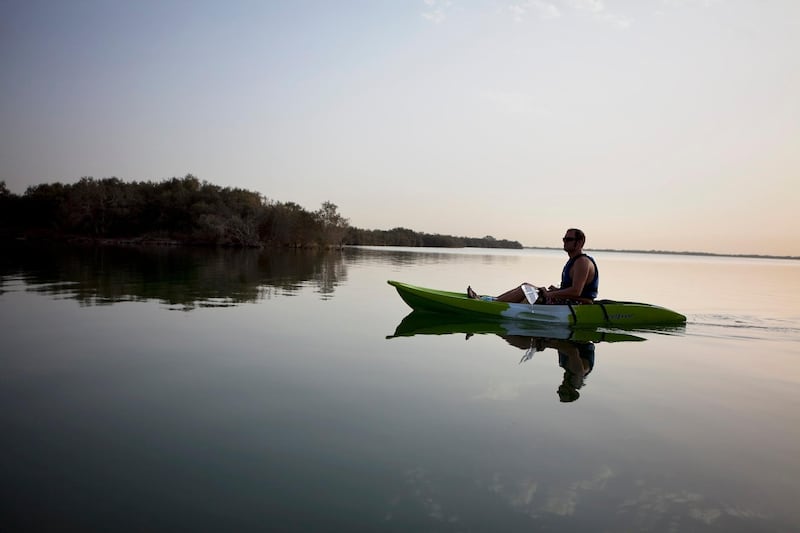 Kayakers navigate the cool early-morning waters on Thursday, July 21, 2011,  between mangrove islands at the mangroves near the East Road in Abu Dhabi. Mangroves, natural saline habitants, are affected by erosion caused by development of the surrounding islands, widening the natural channels and thus increasing the water flow, which in return washes away the sediment much faster. (Silvia Razgova/The National)