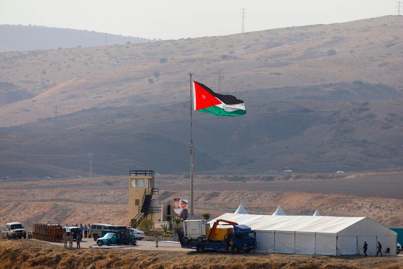 A picture taken from the Israeli side of the border shows Jordanian soldiers raising the national flag ahead of a ceremony at Baqura in Jordan, east of the Jordan river. AFP
