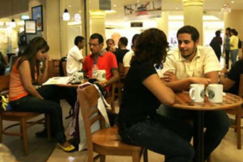 Living in a different world: Customers sitting at a Starbucks in Cairo can buy expensive coffee but the majority struggle with food prices.