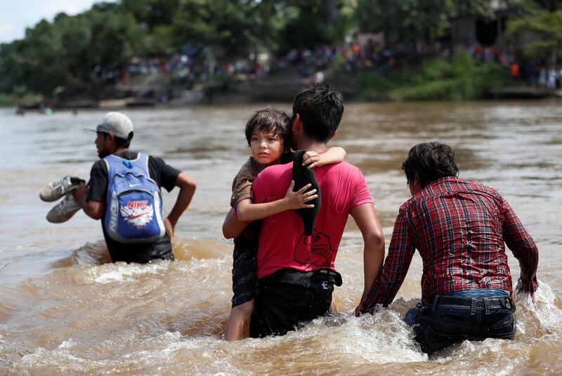 Migrants struggle to cross the river from Guatemala to Mexico in Ciudad Hidalgo. Reuters