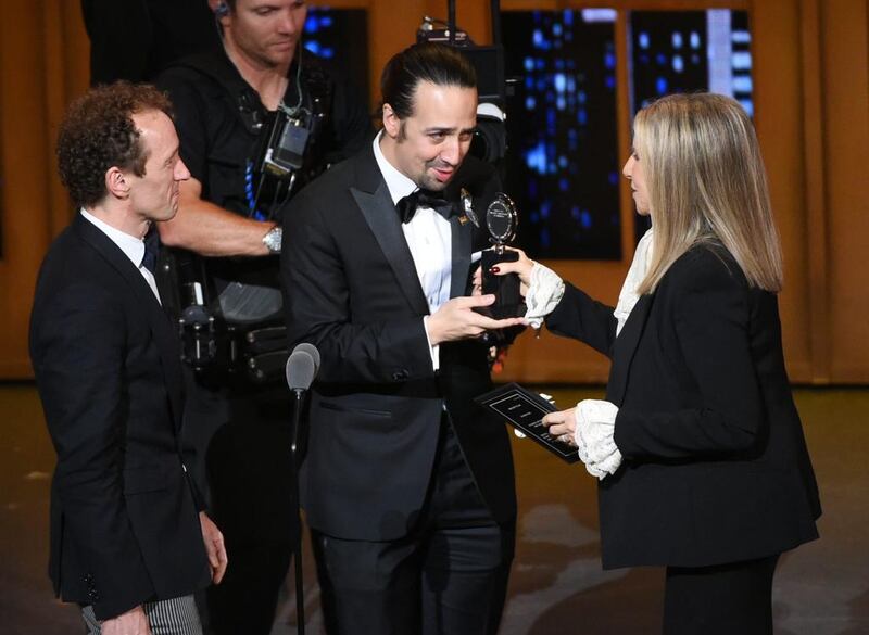 Hamilton producer Jeffrey Seller, left, and creator and star Lin-Manuel Miranda receive the best-musical award from Barbra Streisand. It was one of 11 awards the Broadway show won. Evan Agostini / Invision / AP 