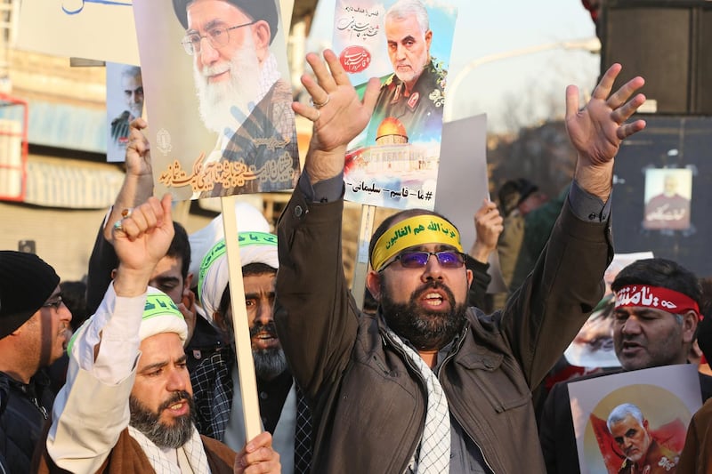 Iranian demonstrators hold placards bearing the images of military commander Qassem Suleimani and Iran's Supreme Leader Ayatollah Ali Khamenei in front of the British embassy in the capital Tehran on January 12, 2020. AFP