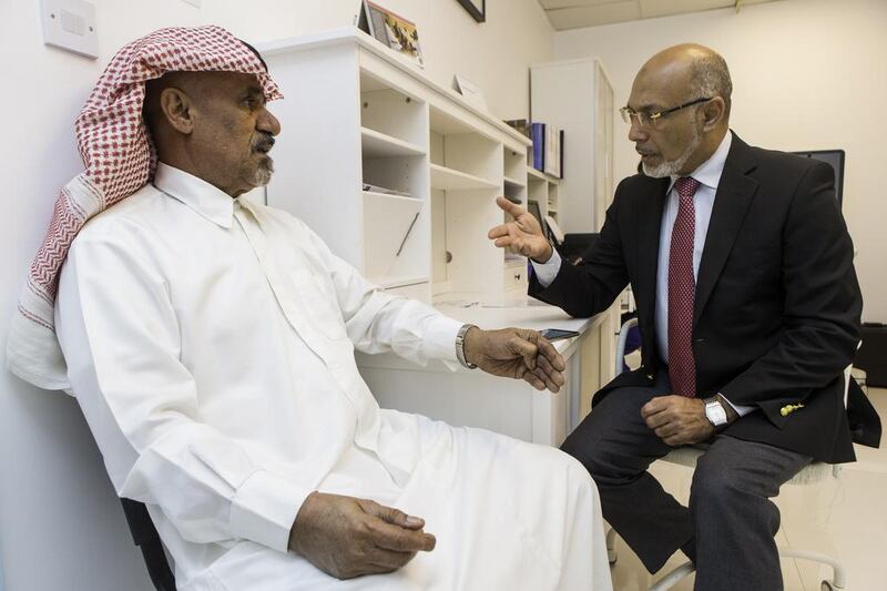Dr Majid Bassuni, right, discusses Emirati patient Hassan Hamadi’s health. Mr Hamadi is a colon cancer survivor and his condition is in remission. Christopher Pike / The National