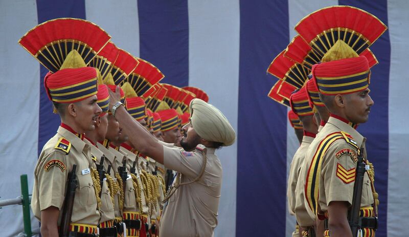 A policeman adjusts his colleague's headdress during a dress rehearsal ahead of India's Independence Day celebrations at the Red Fort in Delhi August 13, 2011. India commemorates its Independence Day on August 15. REUTERS/B Mathur (INDIA - Tags: ANNIVERSARY POLITICS MILITARY) *** Local Caption ***  DEL01_INDIA-_0813_11.JPG