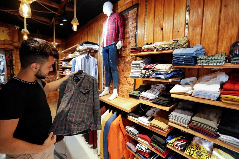 A man buys clothes in a shop, in preparation for Eid al-Fitr, marking the end of the Muslim fasting month of Ramadan, following the outbreak of the coronavirus disease (COVID-19), in Baghdad, Iraq. REUTERS