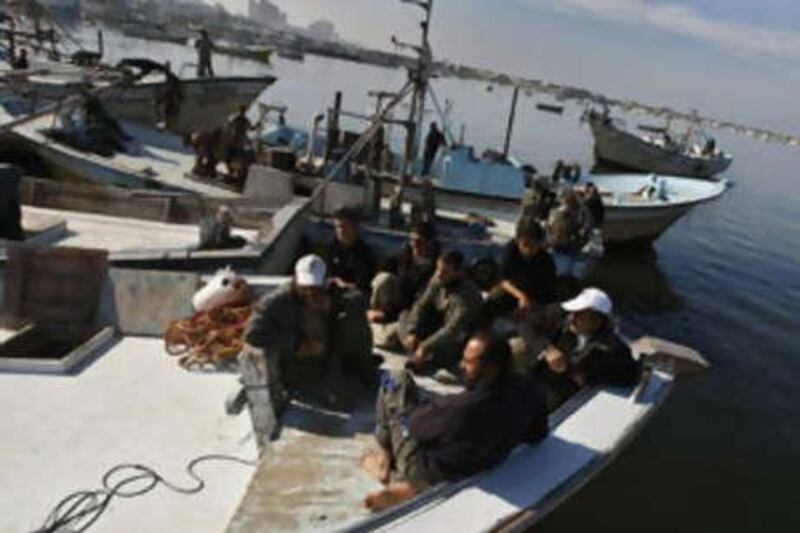 Palestinian workers wait at the port in Gaza City on Dec 1 2008, for the arrival of a Libyan aid ship.