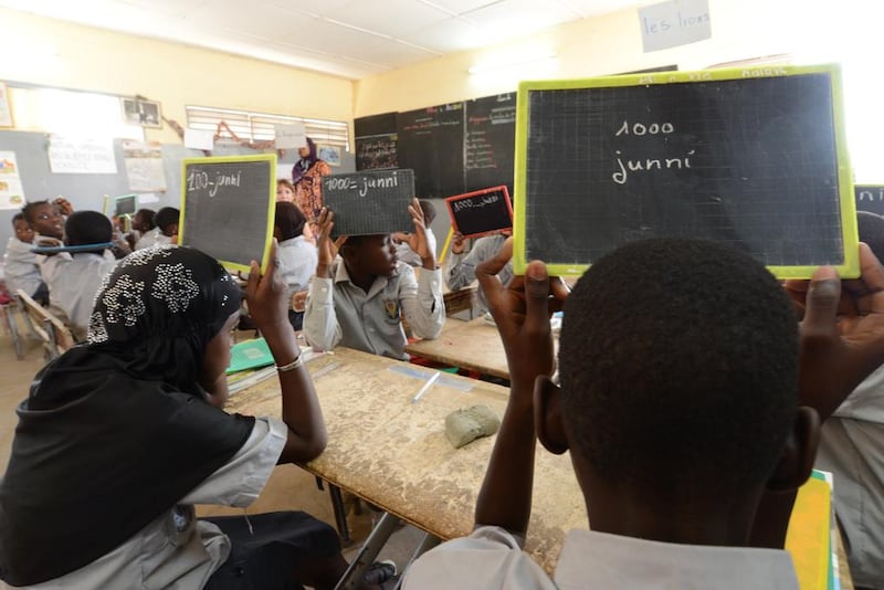 Amy Diouf teaches students maths during a session where they will repeat the same subject in both French and their local language, Wolof. Naser Al Wasmi / The National