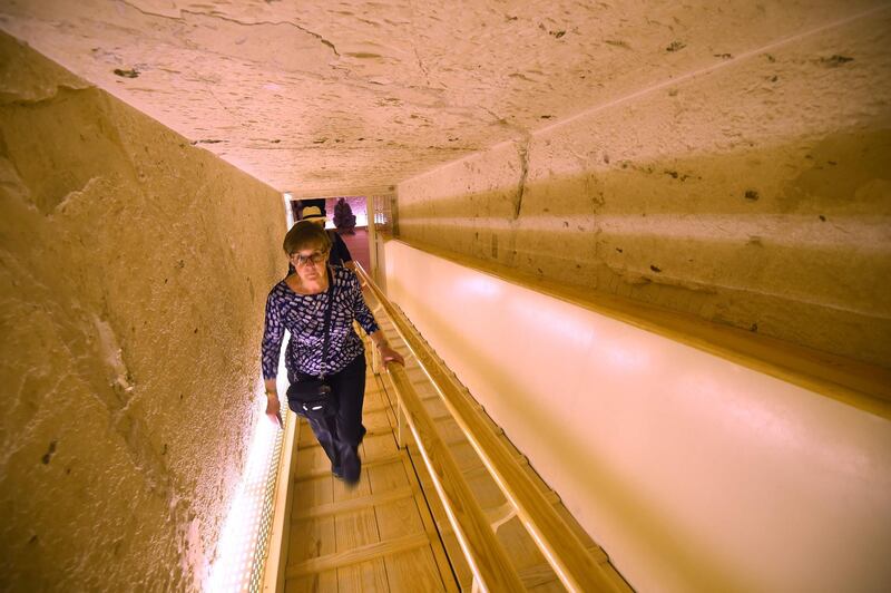 A woman ascends the tunnel leading out of the restored underground tomb. AFP