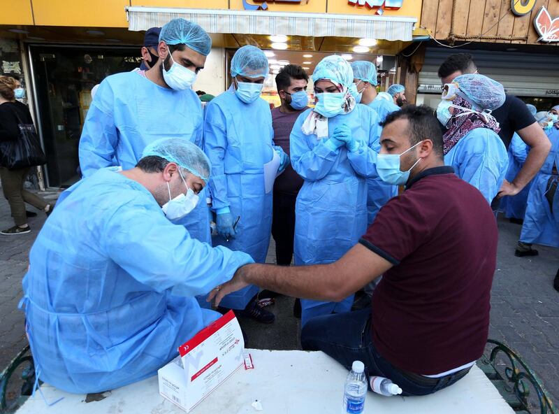Iraqi medical specialists take a blood sample from a man in Baghdad's Karada district, Iraq.  EPA