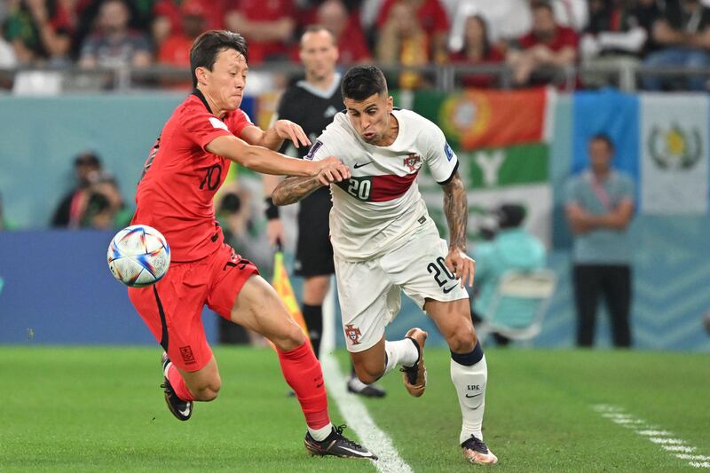 South Korea's Lee Jae-sung fights for the ball with Portugal's Joao Cancelo during the Qatar 2022 World Cup. AFP