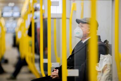 A man sits in the subway wearing an FFP2 mask in Berlin, Germany, Wednesday, Jan. 20, 2021.. During the federal-state talks on the measures against the Corona pandemic, some rules were tightened. For example, the more protective FFP2 masks or surgical masks must be worn on buses and trains and when shopping. The federal states decide for themselves when the new rules will apply. (Christoph Soeder/dpa via AP)