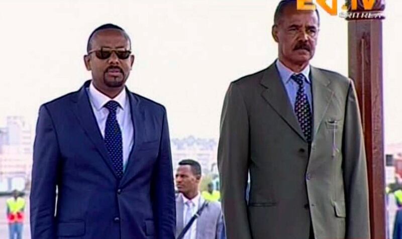 In this grab taken from video provided by ERITV, Ethiopia's Prime Minister Abiy Ahmed, left and Erirea's President Isaias Afwerki observe the Guard or Honour during a welcome ceremony for Ahmed, in Asmara, Eritrea, Sunday, July 8, 2018. With laughter and hugs, the leaders of longtime rivals Ethiopia and Eritrea met for the first time in nearly two decades Sunday amid a rapid and dramatic diplomatic thaw aimed at ending one of Africa's longest-running conflicts. (ERITV via AP)