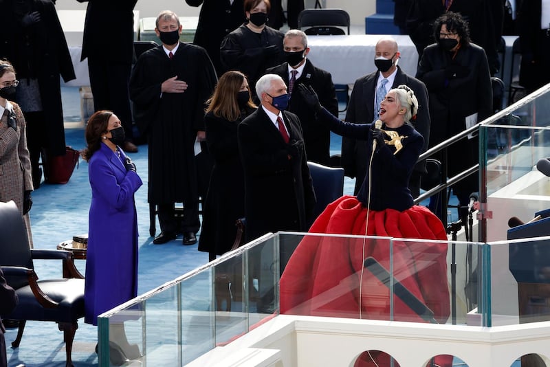 Lady Gaga sings the National Anthem as US Vice President Mike Pence and Vice President-elect Kamala Harris look on. Reuters