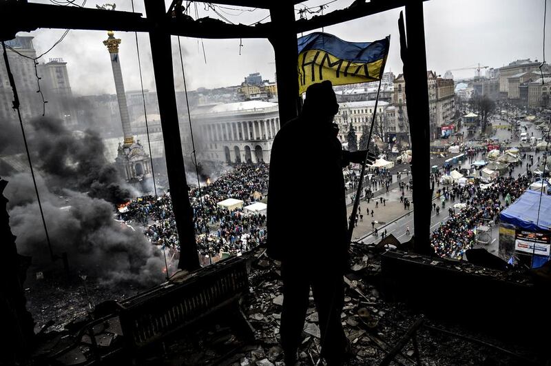 A demonstrator stands on a balcony overlooking Independence square is seen during the face off against heavily-armed police. Armed protesters stormed police barricades in renewed violence that killed at least 26 people and shattered an hours-old truce as EU envoys held crisis talks with Ukraine’s embattled president. Bulent Kilic / AFP